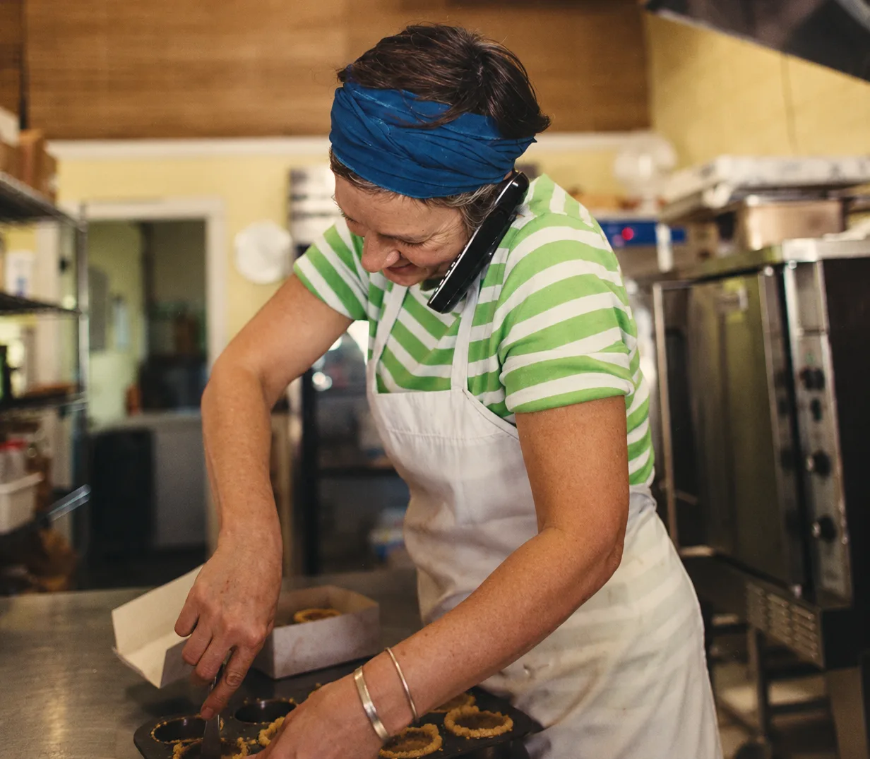 A business owner on the phone while working in a kitchen