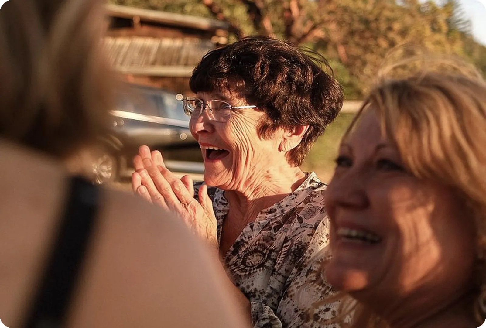 Friends laughing together outdoors at golden hour