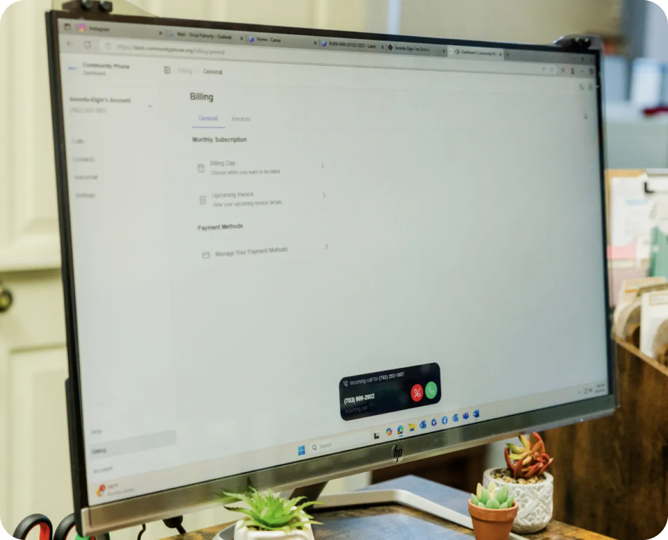 Desktop monitor showing the Community Phone dashboard with an incoming call